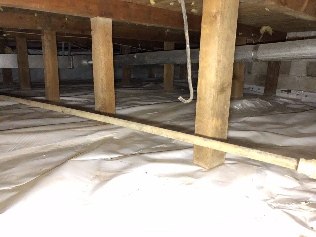 Crawlspace with installed vapor barrier and sealed ground for moisture control under a home